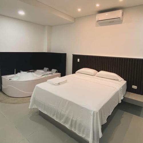 a bedroom with a large bed and a bath tub at Dreams hostel in Neiva