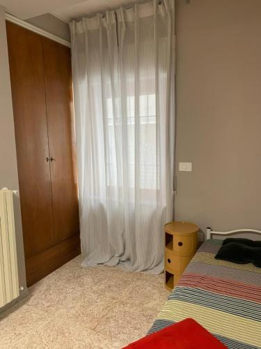 a bedroom with a bed and a window with curtains at Casa Virgilio in Venosa