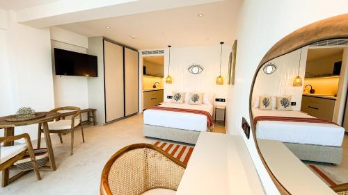 a hotel room with two beds and a table at Sirena Bay Beach House and Luxury Suites in Protaras