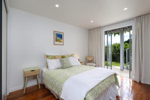 a bedroom with a bed and a large window at The Land - Paradise to Share East Wing in Tata Beach