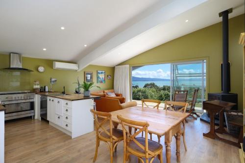 a kitchen and living room with a table and chairs at The Land - Paradise to Share East Wing in Tata Beach