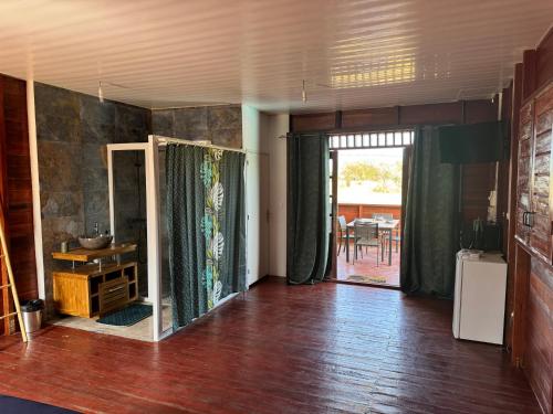 a living room with a door open to a dining room at MONSTERA Bungalow Atypique avec piscine privative in Kourou