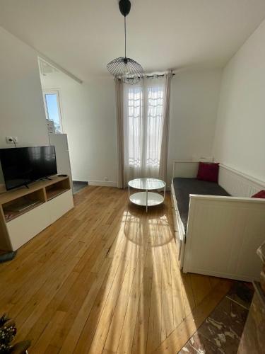 un salon avec un canapé et une table dans l'établissement F1 lumineux au cœur d'Argenteuil, à Argenteuil