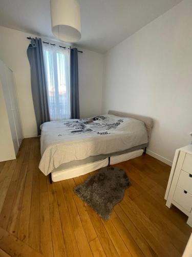 une chambre avec un lit et un parquet dans l'établissement F1 lumineux au cœur d'Argenteuil, à Argenteuil