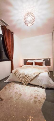 une chambre avec un grand lit et un lustre dans l'établissement Villa d'artistes, à Malras