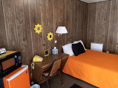 una camera d'albergo con letto e scrivania con telefono di Crawford Motel a Springfield