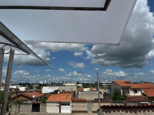 einen Blick aus dem Fenster einer Stadt mit Dächern in der Unterkunft casa 3 quartos1suíte com frigobar smart tv netflix ar-condicionado in Campina Grande