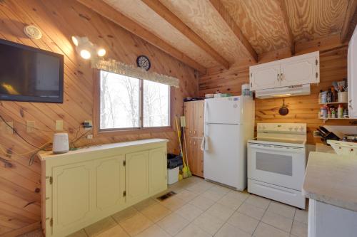 a kitchen with a white refrigerator and a tv at Waterfront Nelson Lake Cabin with Boat Dock! in Hayward