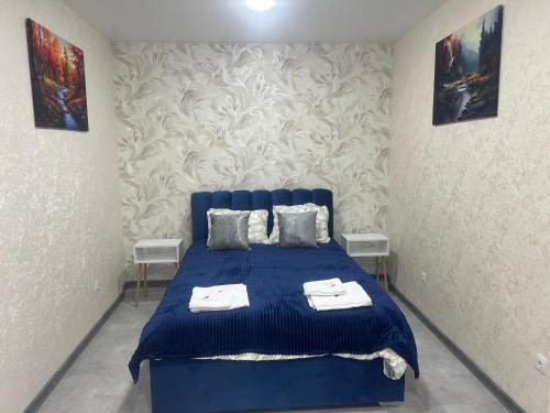 a blue bed in a room with two tables at Cornicello guest haus in Tbilisi City