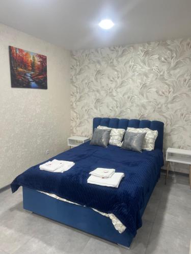 a bedroom with a blue bed with towels on it at Cornicello guest haus in Tbilisi City