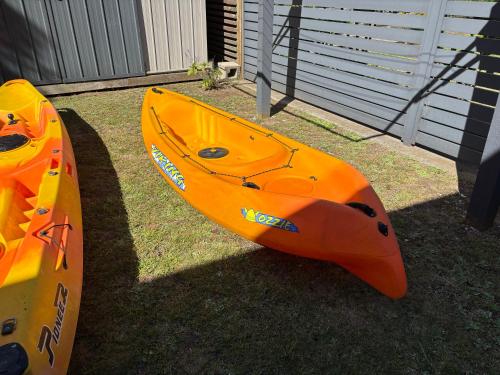 an orange kayak is sitting on the grass at Aquila Nest in Whitianga