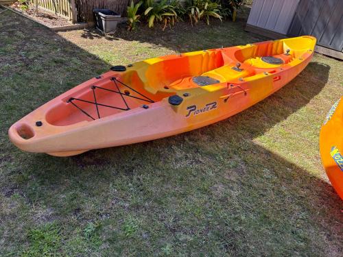 a yellow and orange kayak sitting on the grass at Aquila Nest in Whitianga