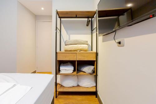 a room with a bunk bed with white sheets at Edifício ASA | Conforto e Conveniência no Coração de Curitiba | Gonzaga Stays in Curitiba