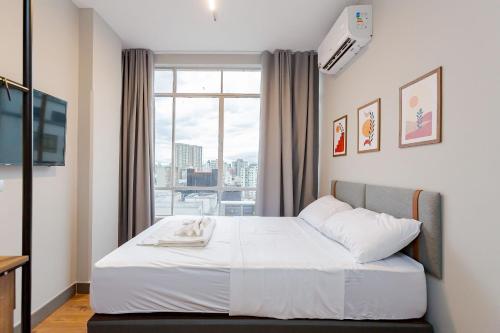 a bedroom with a bed and a large window at Edifício ASA | Conforto e Conveniência no Coração de Curitiba | Gonzaga Stays in Curitiba