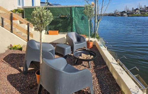a group of chairs and a fire pit next to the water at Awesome Home In Milly-Sur-Thérain in Milly-sur-Thérain