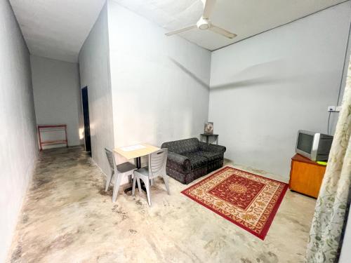 a living room with a couch and a table at Budget Rest House Padang Besar in Padang Besar