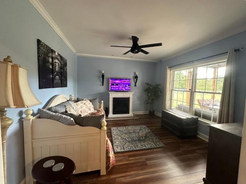 a living room with a ceiling fan and a tv at Pillow and Paddock B&B in La Grange