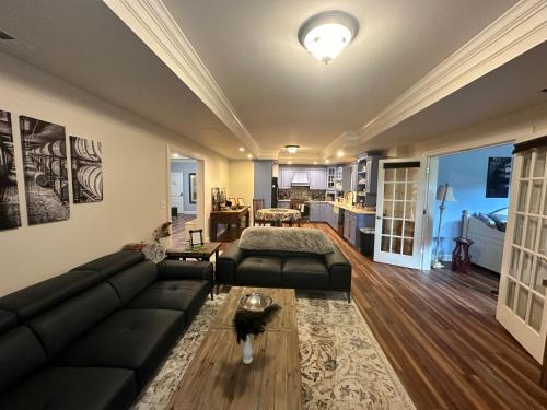 a living room with a black couch and a table at Pillow and Paddock B&B in La Grange