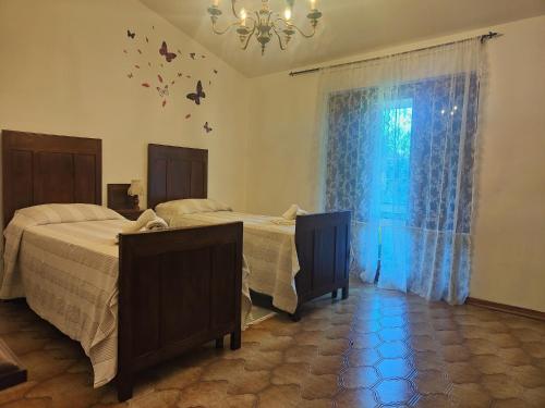 a bedroom with two beds and a window with butterflies on the wall at Holiday Home Camaiore near Lido Beaches in Camaiore