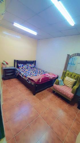a bedroom with a bed and a chair in it at Furnished Bedroom with beside or out side bathroom in Sharjah