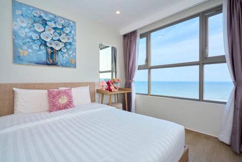 a bedroom with a bed and a large window at THE SONG- CĂN HỘ DU LỊCH 5SAO- FREE hồ bơi- Gần biển - LUXYRY PALM HOME in Vung Tau