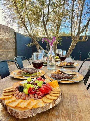 a table with a plate of food and glasses of wine at Finca Cazosa in Valle de Guadalupe