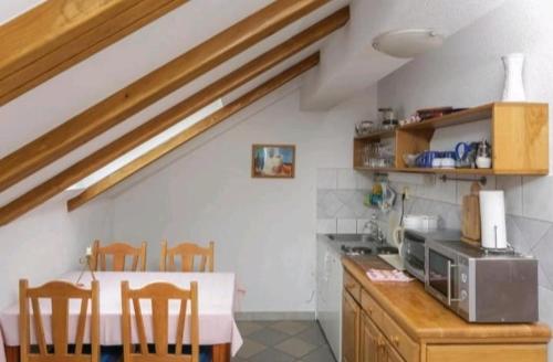 a kitchen with a table with chairs and a microwave at Apartments and rooms by the sea Slano, Dubrovnik - 2178 in Slano