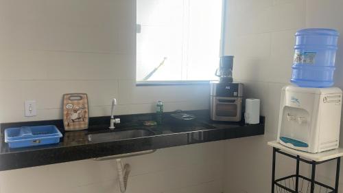 a kitchen counter with a sink and a coffee maker at Viver de Temporada Canindé- 15 Minutos de Piranhas in Canindé de São Francisco
