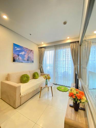 a living room with a couch and a table at THE SONG- CĂN HỘ DU LỊCH 5SAO- FREE hồ bơi- Gần biển - LUXYRY PALM HOME in Vung Tau