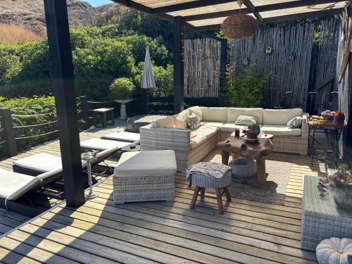 a patio with a couch and chairs on a deck at B&B Casa Las Brisas Matanzas in Matanzas