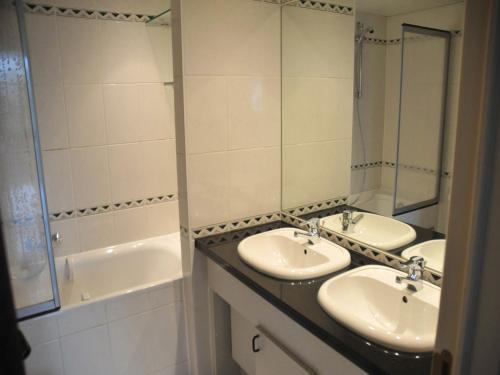 a bathroom with two sinks and a bath tub at Apt w Fireplace & Garden in Durbuy