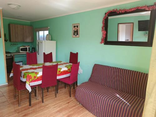 a kitchen with a table and chairs and a couch at Cabaña YEYITA Playa Las Ventanas in Puchuncaví