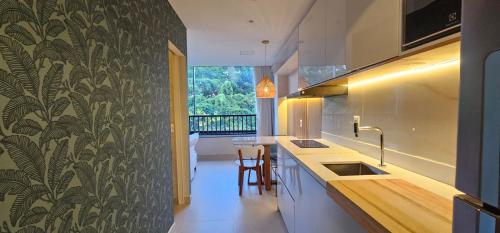 a kitchen with a wall with a leafy wallpaper at Luxo na Gloria in Rio de Janeiro