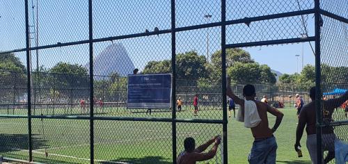 a group of people playing baseball in a batting cage at Luxo na Gloria in Rio de Janeiro
