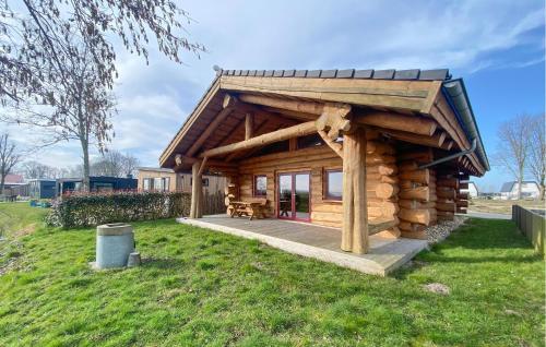 a log cabin with a deck in the grass at 3 Bedroom Lovely Home In Den Oever in Den Oever