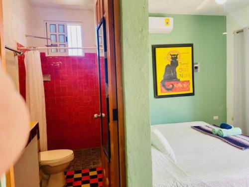a bathroom with a toilet and a red shower at Casa Kini en Cancún in Cancún