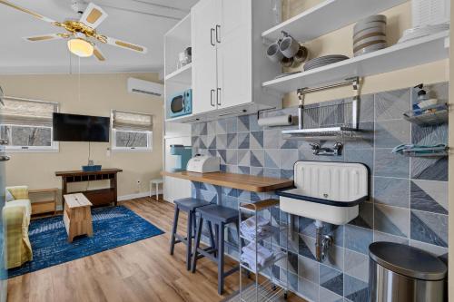 a kitchen with a sink and a counter with stools at Cozy apartment, private beach & jacuzzi in Westbrook