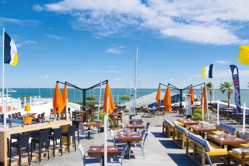 a row of tables and chairs with umbrellas on the beach at Peaceful Villa in Castle Park in Salles