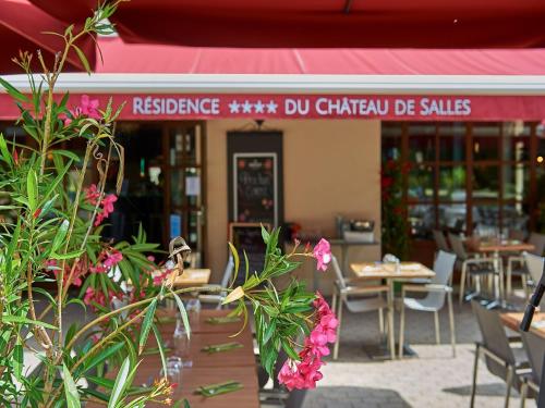 a restaurant with tables and chairs and pink flowers at Peaceful Villa in Castle Park in Salles