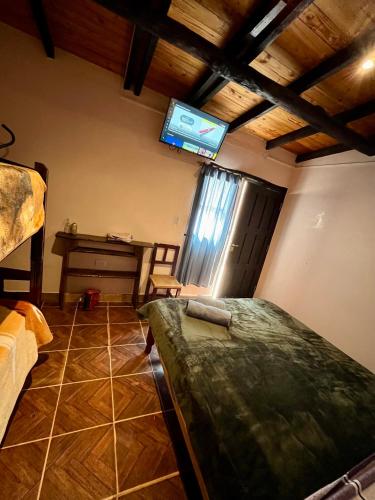 a bedroom with a bed and a tv on the wall at Faustina in Purmamarca