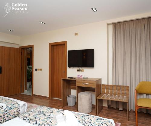 a hotel room with a desk and a tv on the wall at Golden Season Hotel in Cairo