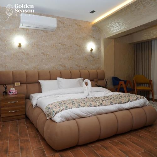 a bedroom with a large bed with a brown tufted headboard at Golden Season Hotel in Cairo
