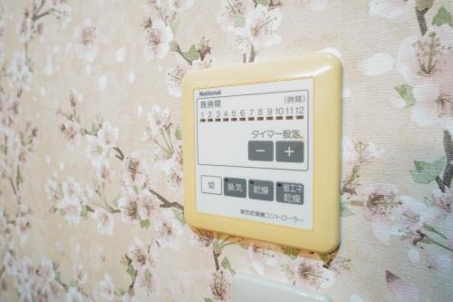 a clock on a wall with flowers on it at KAMON relaxing, Japanese spacious room in Osaka