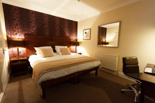 a bedroom with a bed and a desk and a mirror at Town House Rooms in Hastings