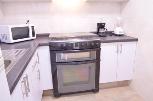 eine Küche mit Herd und Mikrowelle in der Unterkunft Casa Blue El place ideal for tu descanso in Puebla