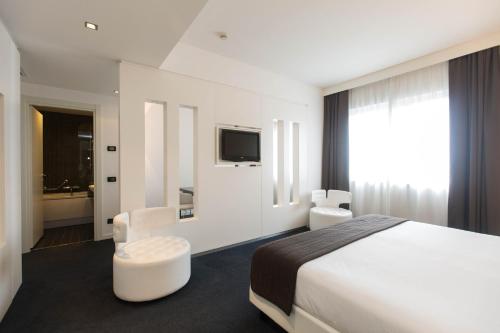 ein Hotelzimmer mit einem Bett und einem TV in der Unterkunft iH Hotels Roma Z3 in Rom