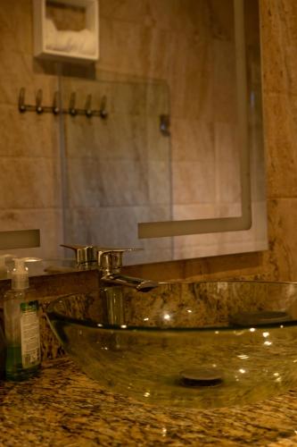 a bathroom with a glass sink and a mirror at Villa Tierrita in Santa Bárbara de Samaná