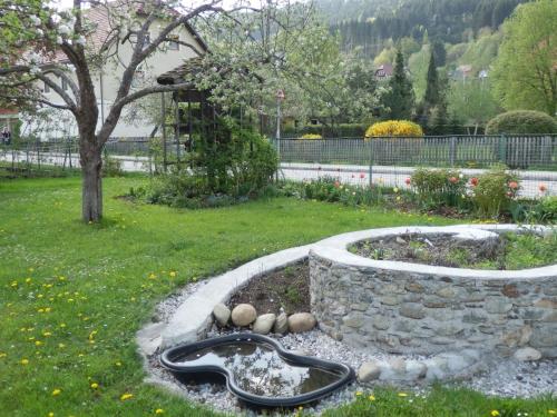 a garden with a snake statue in the grass at Kronenwirt in Gurk