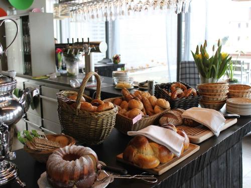 einen Tisch mit Körben mit Brot und Gebäck darauf in der Unterkunft Hotel mein inselglück in Reichenau