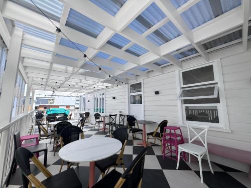 a dining room with tables and chairs on a balcony at K2 Brisbane in Brisbane